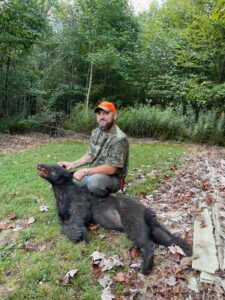 Art Thomm with a Bear he Harvested